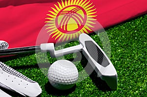 Golf ball and club with flag of Kyrgyzstan on green grass. Golf championship in Kyrgyzstan