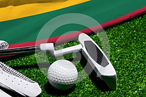 Golf ball and club with flag of Lithuania on green grass. Golf championship in Lithuania