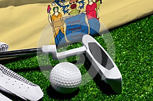 Golf ball and club with flag of New Jersey on green grass. Golf championship in New Jersey