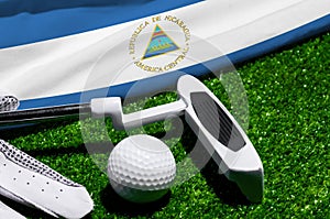 Golf ball and club with flag of Nicaragua on green grass. Golf championship in Nicaragua
