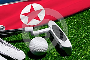 Golf ball and club with flag of North Korea on green grass. Golf championship in North Korea