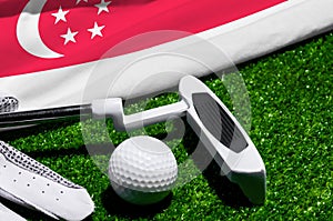Golf ball and club with flag of Singapore on green grass. Golf championship in Singapore