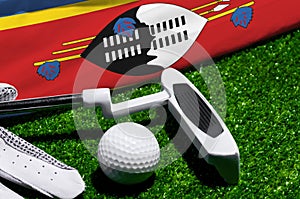 Golf ball and club with flag of Swaziland on green grass. Golf championship in Swaziland