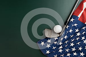 Golf ball and golf club with flag of USA on green table background, sport concept