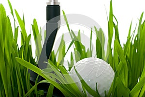 Golf ball with club on grass - isolated