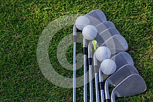 Golf ball and golf club on green grass background