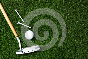 Golf ball, club and tees on artificial grass, top view