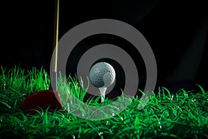 Golf ball driver and tee on green grass field