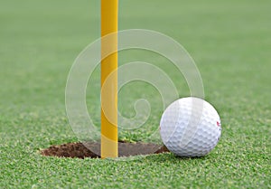 Golf ball on the edge of the cup