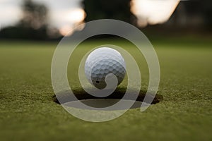 Golf ball on edge of hole, intense focus, anticipation for decisive shot. photo