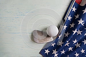 Golf ball with flag of USA on wood blue table background