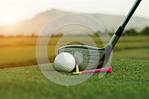 Golf ball and golf club in beautiful golf course at sunset background