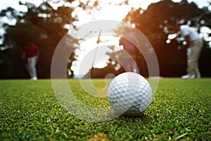 Golf ball and golf club in beautiful golf course at sunset background