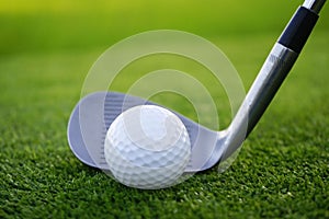 Golf ball and golf club in beautiful golf course at sunset background. Golf ball on green in golf course at Thailand