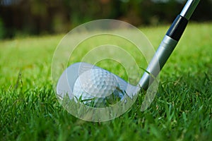 Golf ball and golf club in beautiful golf course at Thailand. Collection of golf equipment resting on green grass with green