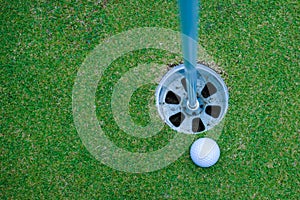 Golf ball and golf club in the beautiful golf course in Thailand. Collection of golf equipment resting on green grass with green