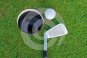 Golf ball and golf club in beautiful golf course at Thailand. golf equipment resting on green grass background