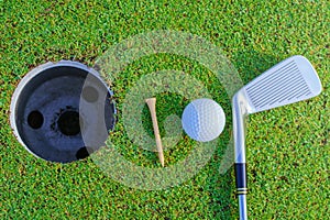 Golf ball and golf club in beautiful golf course at Thailand. golf equipment resting on green grass background