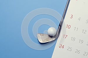 Golf ball , golf club and calendar on blue background