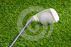 Golf ball and golf club on grass