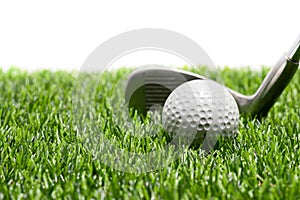Golf ball and golf club on grass on white background