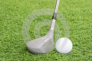 Golf ball and golf club on green grass