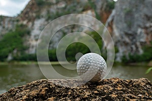 Golf ball on grass near small lake