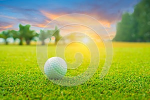 Golf ball on green in beautiful golf course with sunset. Golf ball close up in golf coures at Thailand photo