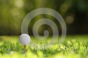 Golf ball on green grass with golf course background