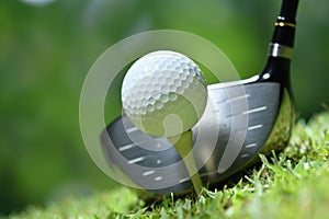 Golf ball on green grass ready to be struck on golf course