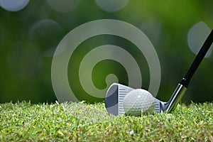 Golf ball on green grass ready to be struck on golf course