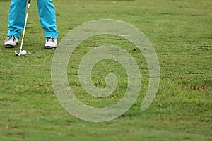 Golf ball on green grass ready to be struck on grass background