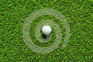 Golf ball on green grass texture of golf course for background.