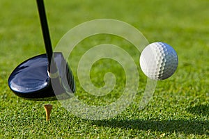 Golf ball hit off the tee with driver on golf cour photo