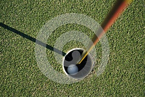 Golf ball is beside the hole