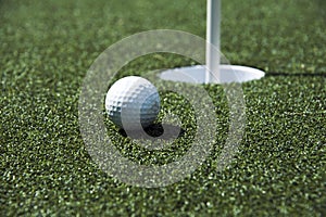 Golf ball and hole on a field photo