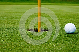 A golf ball in the hole green