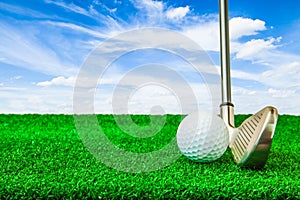 Golf ball and iron on artificial green grass