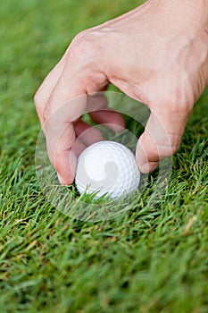 Golf ball and iron on green grass detail macro