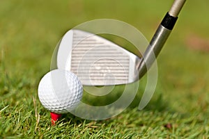 Golf ball and iron on green grass detail macro summer outdoor