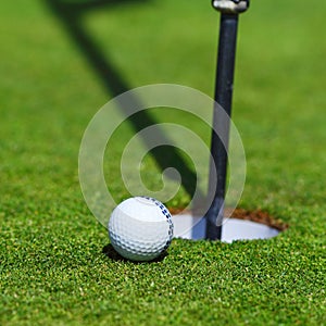 Golf ball on lip of cup