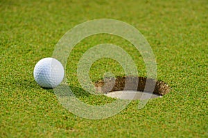 Golf ball on lip of cup