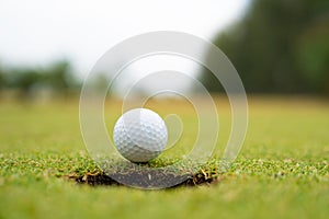 Golf ball on lip of cup close up, Golf ball on the lawn