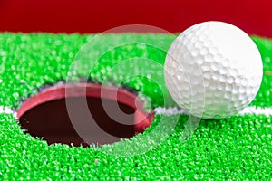 Golf ball on lip of cup, goal concept