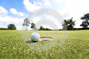 Golf ball near hole,