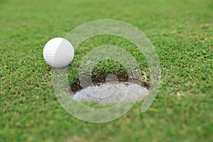 Golf ball near hole on course