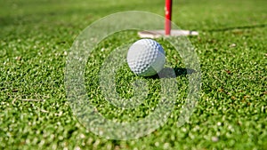 Golf ball near hole with flag