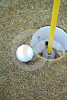Golf Ball next to hole