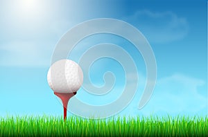 Golf ball on red tee, grass and blue sky