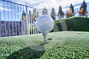 golf ball on a tee on an artificial turf driving range